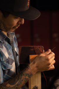 A photo of a man doing leatherwork.