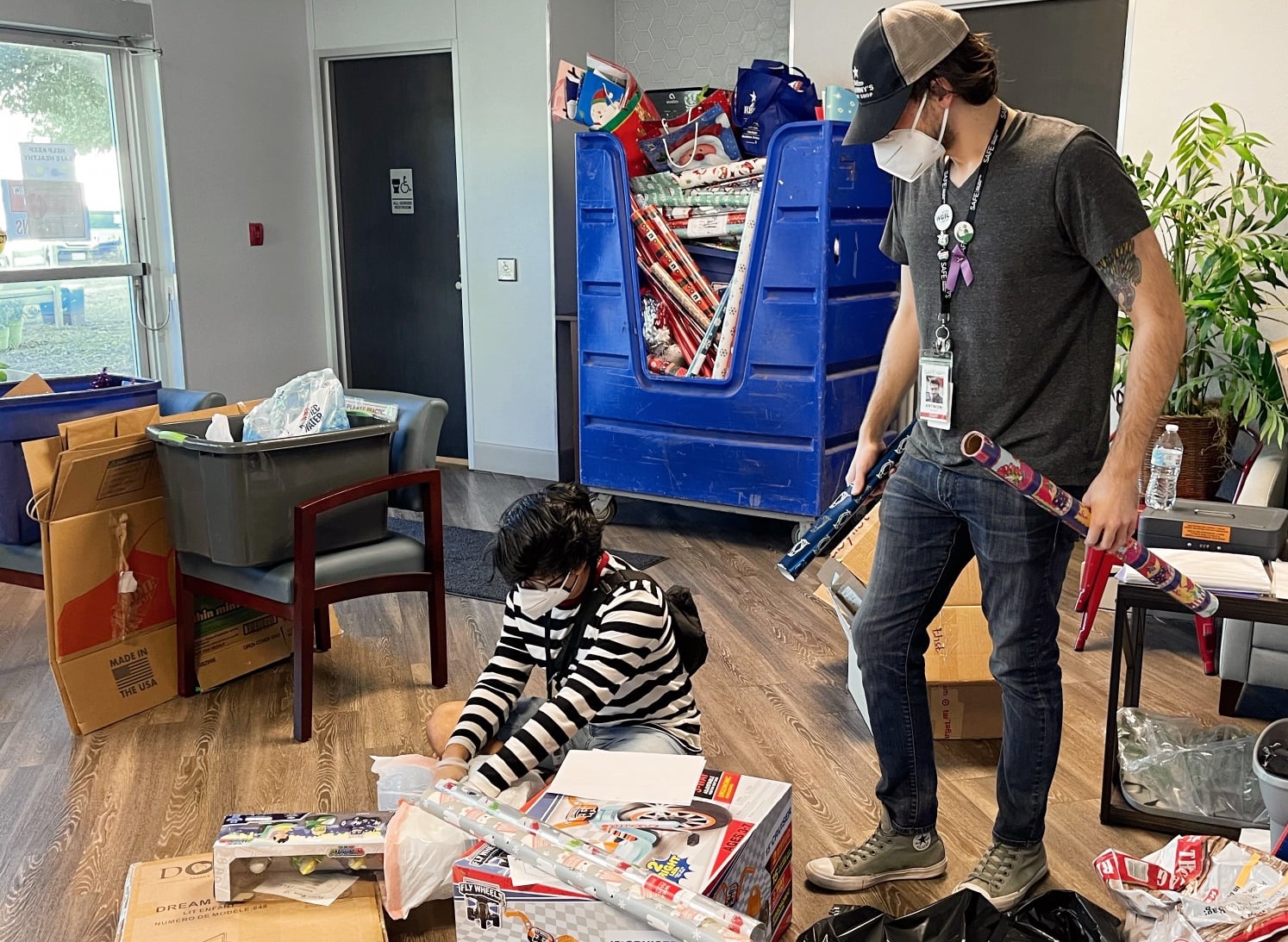 A photo of two strong boys helping sort presents at the SAFE Family Shelter.