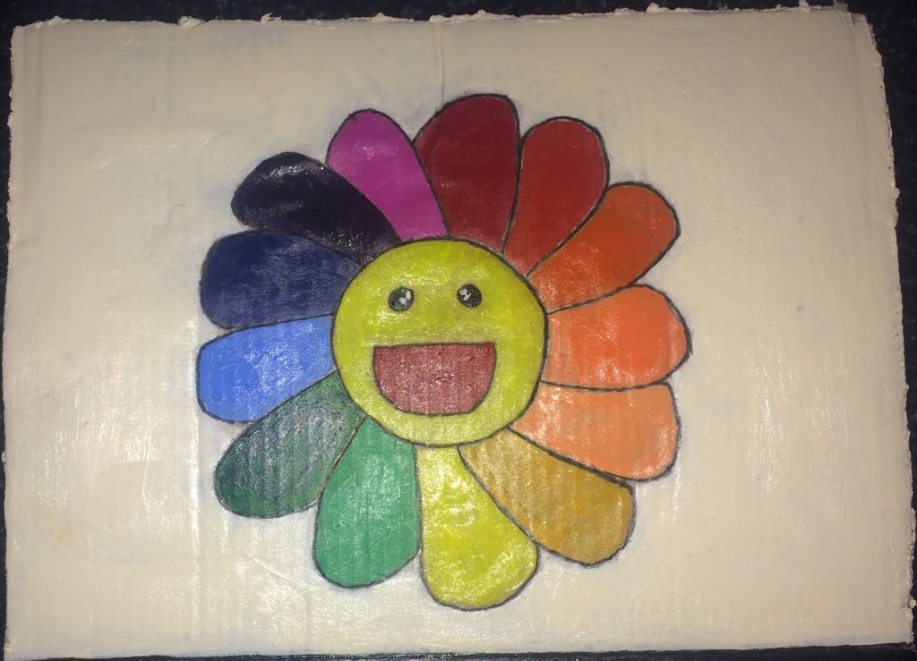 Descripción de la imagen: Pintura de una flor sonriente. Cada pétalo es de un color diferente del arco iris. La pintura está sobre un fondo blanco. 