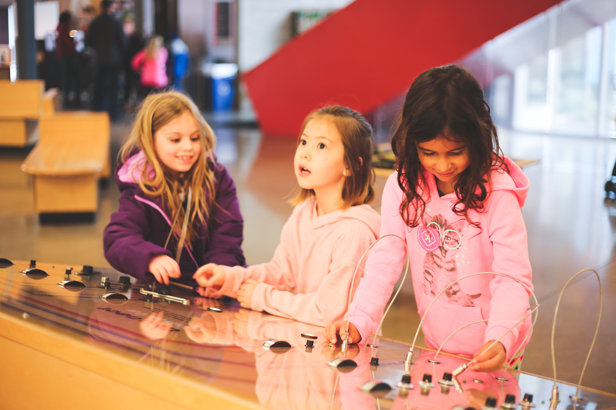 Descripción de la imagen: Una fotografía de tres niñas en el museo infantil Thinkery.