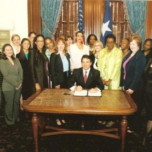 Descripción de la imagen: Una foto de los legisladores firmando la ley HB 121, que obliga a los distritos escolares de Texas a adoptar y aplicar una política de violencia en el noviazgo.