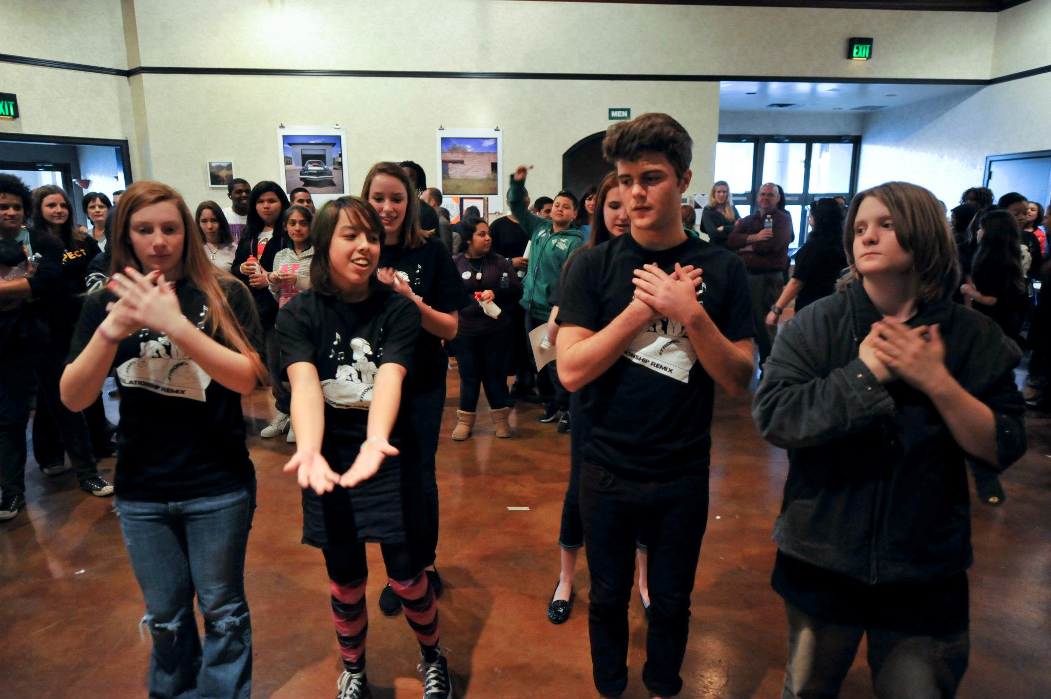 Descripción de la imagen: Una foto de una habitación llena de adolescentes practicando una rutina de baile.