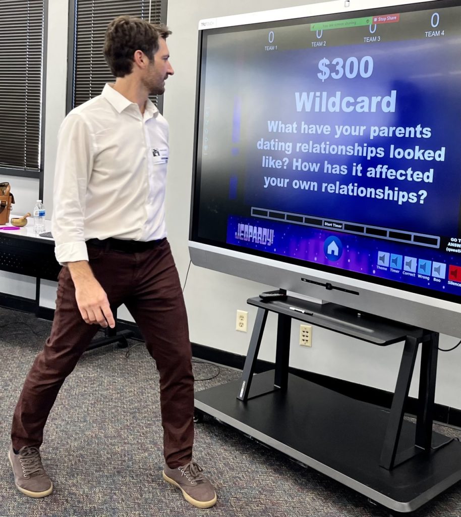 Image description: A man, Adam Klaybor, is standing in front of a television monitor giving a presentation.