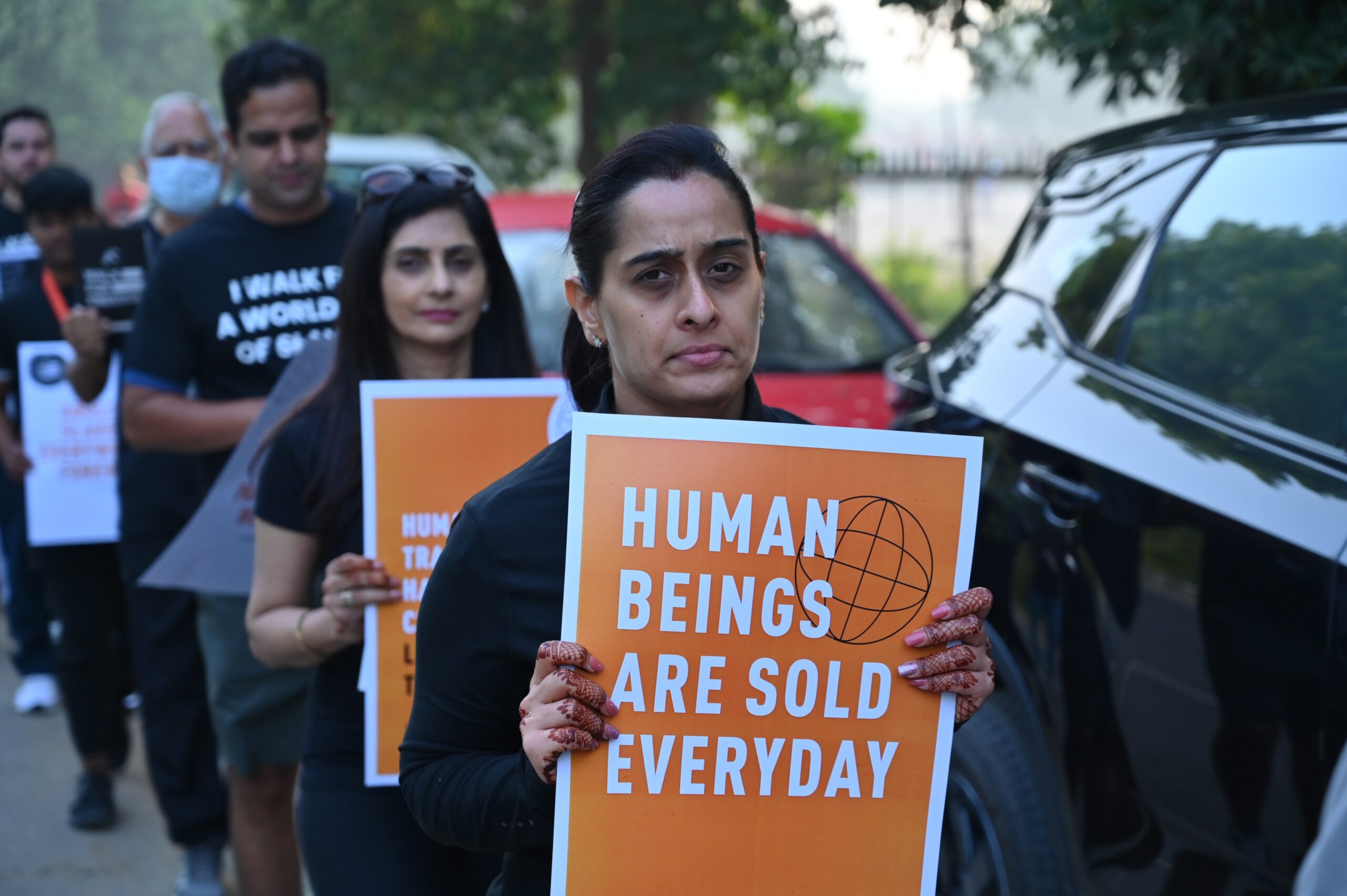 A woman carrying a sign at a Human Trafficking march that says, "Human Beings Are Sold Everyday".