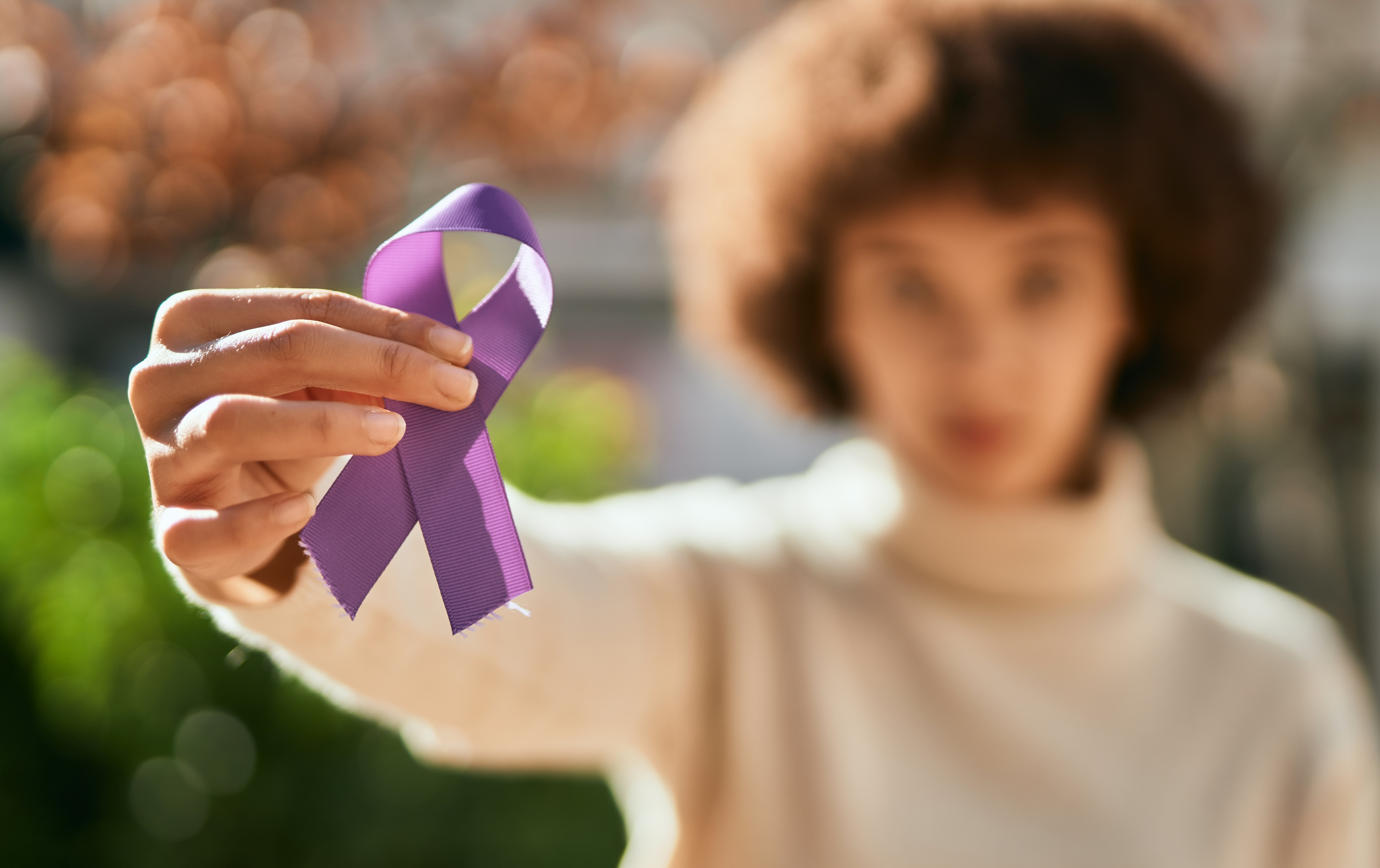 Woman holding purple domestic violence awareness ribbon.