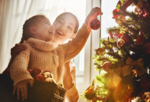 Mom and child decorate a Christmas tree together | Give Christmas trees to families | Christmas trees for families in need | Donate a tree this Christmas 